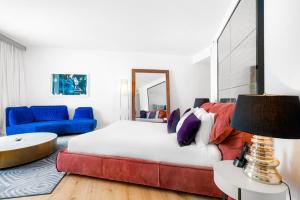 ein Schlafzimmer mit einem Bett, einem Sofa und einem Tisch in der Unterkunft Ocean View Residence at W South Beach -1226 in Miami Beach