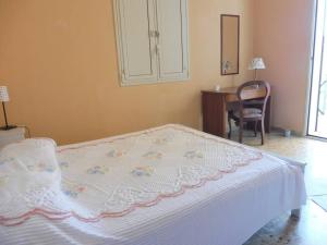 a bedroom with a bed with a table and a chair at Appartamento in Villa a circa 100 metri dal mare in Fontane Bianche