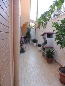 an outdoor courtyard with plants and a fireplace at Appartamento in Villa a circa 100 metri dal mare in Fontane Bianche