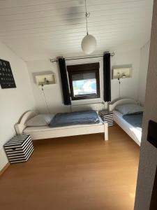 a bedroom with two beds and a window at Eckwarderhörne Objekt B 15 in Großwürden