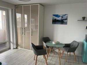 Zimmer mit einem Tisch, 2 Stühlen und einem Glastisch in der Unterkunft Wilhelms Havenkoje - gemütliches Innenstadtappartment in Wilhelmshaven