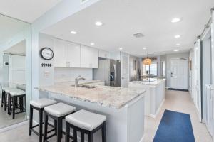 a kitchen with a large island with bar stools at Windjammer 403 in Cedar Landing