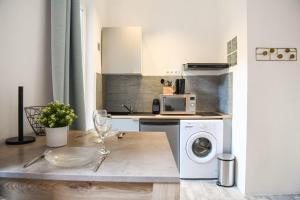 a kitchen with a washing machine and a microwave at Studio cosy avec terrasse au coeur de Marseille in Marseille