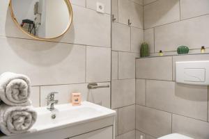 a white bathroom with a sink and a mirror at Studio cosy avec terrasse au coeur de Marseille in Marseille