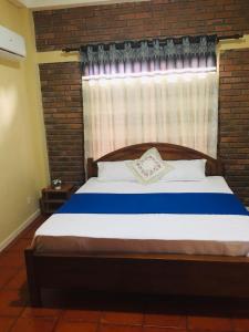 um quarto com uma cama com uma parede de tijolos em Serene Inn Kandana em Kandana