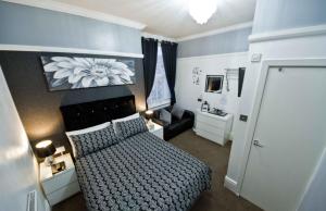 a small bedroom with a bed and a couch at Rossall Guest House -Ideal For Families & Couples in Blackpool