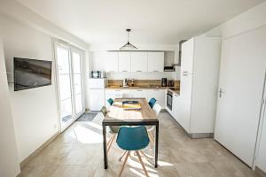 a kitchen with a table and chairs in a room at LE COMMODORE Maison avec piscine/parking/wifi/plages 5kms in Les Mathes