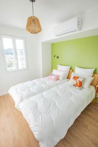 1 cama blanca grande con almohadas en la habitación en LE COMMODORE Maison avec piscine/parking/wifi/plages 5kms en Les Mathes