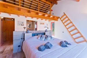 a bedroom with a large white bed with blue pillows at Sierra Melides Villa,Alentejo, BR2 with private pool, BR3 with private pool - near beach in São Francisco da Serra +66 photos