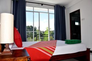 a bedroom with a bed and a large window at Cozy Homestay Kandy in Kandy