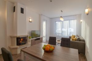 una sala de estar con una mesa con un bol de fruta. en From Sunrise to Sunset at Oak Residence Smolyan Lakes en Pamporovo