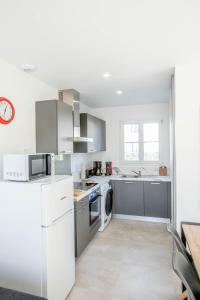 a white kitchen with a sink and a dishwasher at LE VAISSEAU Maison avec piscine/parking/wifi/plages 5kms in Les Mathes