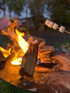un pozzo di fuoco con un pezzo di carta su un bastone di Pousada Container e Spa Mina Beer a Ametista do Sul