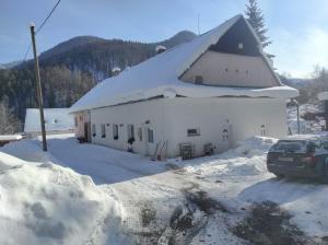 a large white building with a snow covered roof at Penzion Smrekovica in Ružomberok