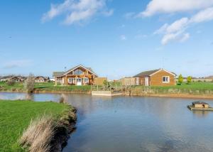 a river with houses and a boat in the water at Hornsea Lakeside Lodges in Hornsea