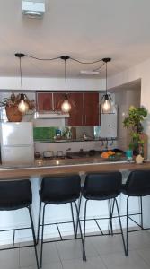 una cocina con encimera con sillas. en Hermoso departamento en Nueva Córdoba 1 hab 3 personas Obispo Oro 344 en Córdoba