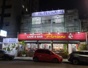 ein rotes Auto, das vor einem Gebäude parkt in der Unterkunft Hotel Natal in Santos