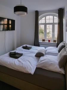a bedroom with a large white bed with a window at Apartment HBF - Erfurt Bahnhof in Erfurt