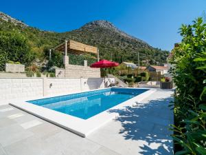 a swimming pool with a mountain in the background at Villa Melita in Trsteno