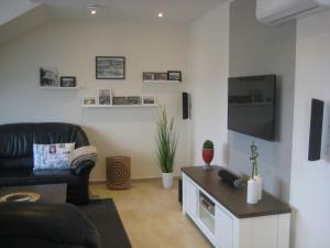 a living room with a couch and a tv at Appartements Buesum DS10 in Büsum