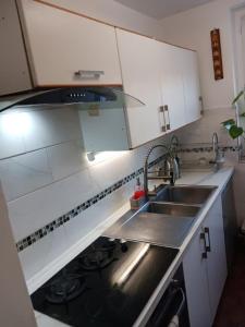 a small kitchen with a sink and a stove at Chambre Cosy et Chambre Sam WIFI PARKING GRATUIT in Rosny-sous-Bois