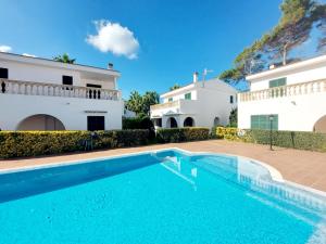 a swimming pool in front of a villa at Xenia in Ciutadella