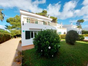 a white house with a bush in front of it at Xenia in Ciutadella