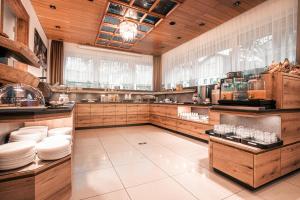 a large kitchen with wooden cabinets and white plates at Hotel-Restaurant Barbarossahof in Kaiserslautern
