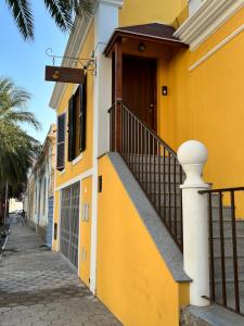 a yellow building with a staircase next to a street at Orietta Residencial in Mindelo
