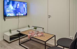 uma sala de estar com uma mesa e uma televisão na parede em Cozy Apartment In rdalstangen With Wifi em Årdalstangen