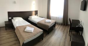 um quarto de hotel com duas camas e uma secretária em Leo Rooms em Lviv