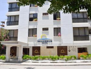 a white building with a sign on it at Hotel Valladolid in Santa Marta