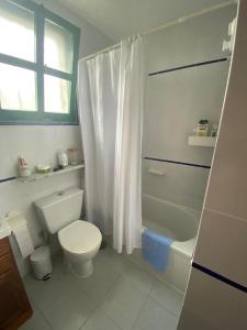a white bathroom with a toilet and a shower at CASA SANDRA COCOSOL in Costa de Antigua