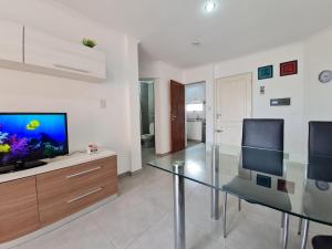 a living room with a glass table and a fish aquarium at Resistencia City Apartment in Resistencia
