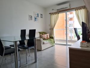 a living room with a glass table and chairs at Resistencia City Apartment in Resistencia