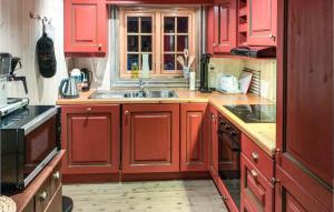 una cocina con armarios rojos y fregadero en Lovely Home In Elg With Kitchen, en Elga