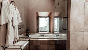 a bathroom with a tub and a sink and a window at Hacienda Sepulveda Hotel & Spa in Lagos de Moreno