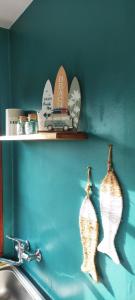 a shelf with two vases on a wall next to a sink at Le Bout des Dunes, baie de Somme in Saint-Quentin-en-Tourmont