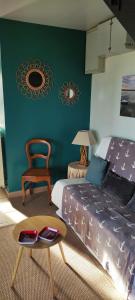 a bedroom with a bed and a table and a chair at Le Bout des Dunes, baie de Somme in Saint-Quentin-en-Tourmont