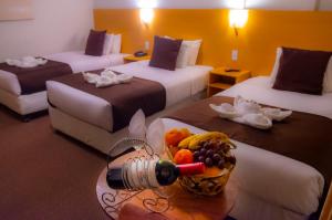 een hotelkamer met 2 bedden en een fruitschaal op een tafel bij Casona Plaza Balsa Inn in Puno