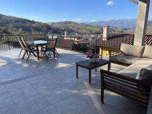 a patio with a couch and a table and chairs at Apartamentos Cangas Relax En Grupo in Cangas de Onís