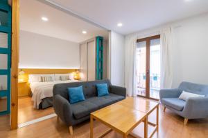 a living room with a bed and a couch and a table at Locksmith Apartment -Wifi- Park Option in Seville