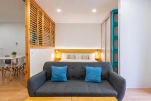 1 dormitorio con 1 cama y 1 sofá con almohadas azules en Locksmith Apartment -Wifi- Park Option, en Sevilla