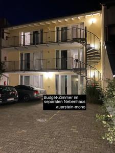 a building with balconies and cars parked in a parking lot at AUERSTEIN-Hotels auerstein & auerstein-mono in Heidelberg