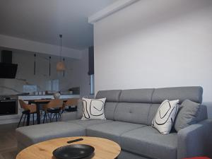 una sala de estar con un sofá y una mesa en Apartament SEVENTH HEAVEN, en Uniejów
