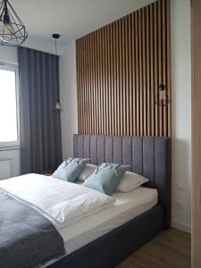 a bedroom with a large bed with blue pillows at Apartament SEVENTH HEAVEN in Uniejow