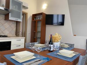 uma cozinha com uma mesa de madeira e copos de vinho em Casita Porto Pino em Porto Pino