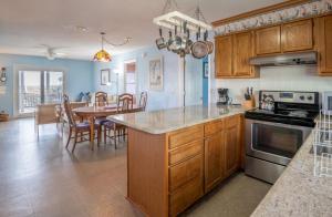 a kitchen with wooden cabinets and a dining room with a table at Oceanfront Carolina Beach House - Dogs Allowed -Near Boardwalk in Carolina Beach +32 photos