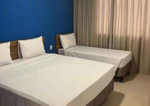 two beds in a room with blue walls at São Pedro Thermas Resort Oficial in São Pedro