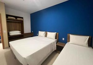 a bedroom with two beds and a blue wall at São Pedro Thermas Resort Oficial in São Pedro
